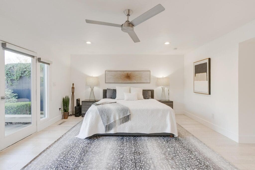 The bright primary bedroom boasts French doors and automatic shades.