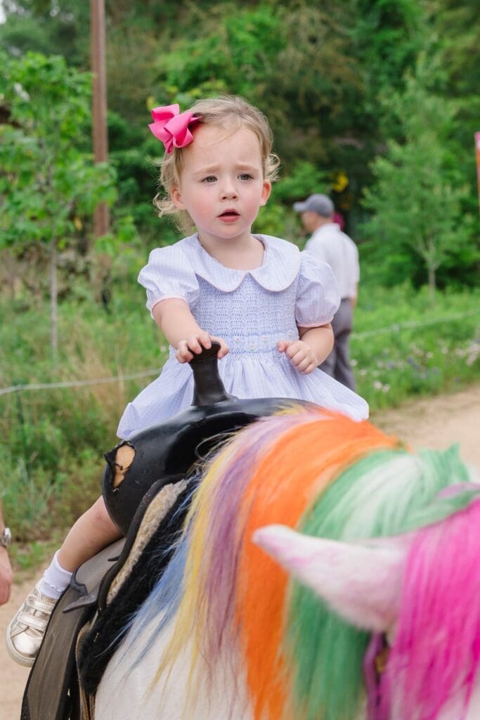 Grace Green enjoys a unicorn ride at the Ambassadors for Texas Children’s Hospital Family Fun Day (Photo by Johnny Than)