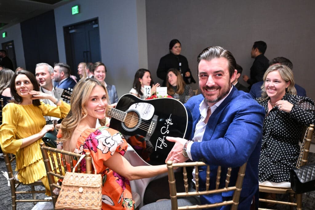 Chea & Lia Kelly with the Taylor Swift autographed guitar that they made the winning bid on at the Houston Classical Charter School gala. (Photo by Daniel Ortiz)