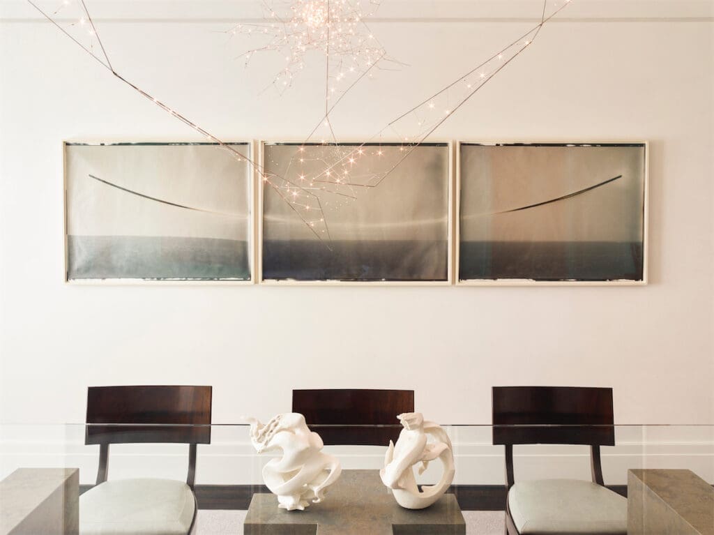 Kaj Gottlob vintage Danish dining chairs in Jerry Pair leather. Custom light fixture, Bastien Carré. Chris McCaw triptych. On table, vintage Sèvres porcelain sculptures. (Photo by Eric Piasecki)