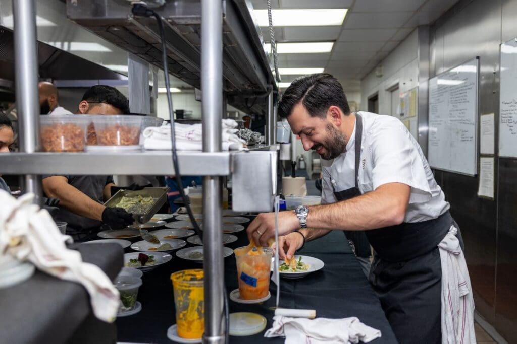 Chef Aaron Bludorn putting finishing touches on his dish at the Houston Ballet 'Raising the Barre' dinner at Caracol. (Photo by Melissa Taylor)
