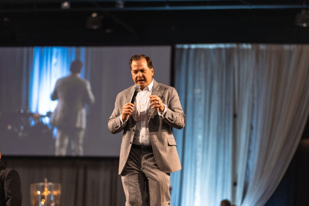 Will Murphy, master of ceremonies, kicking off the live auction which contributed greatly to the nearly $1.6 million raised at the “Now & Then” Celebrating 30 Years” – The Woodlands Christian Academy’s (TWCA) 2024 Auction & Gala.

