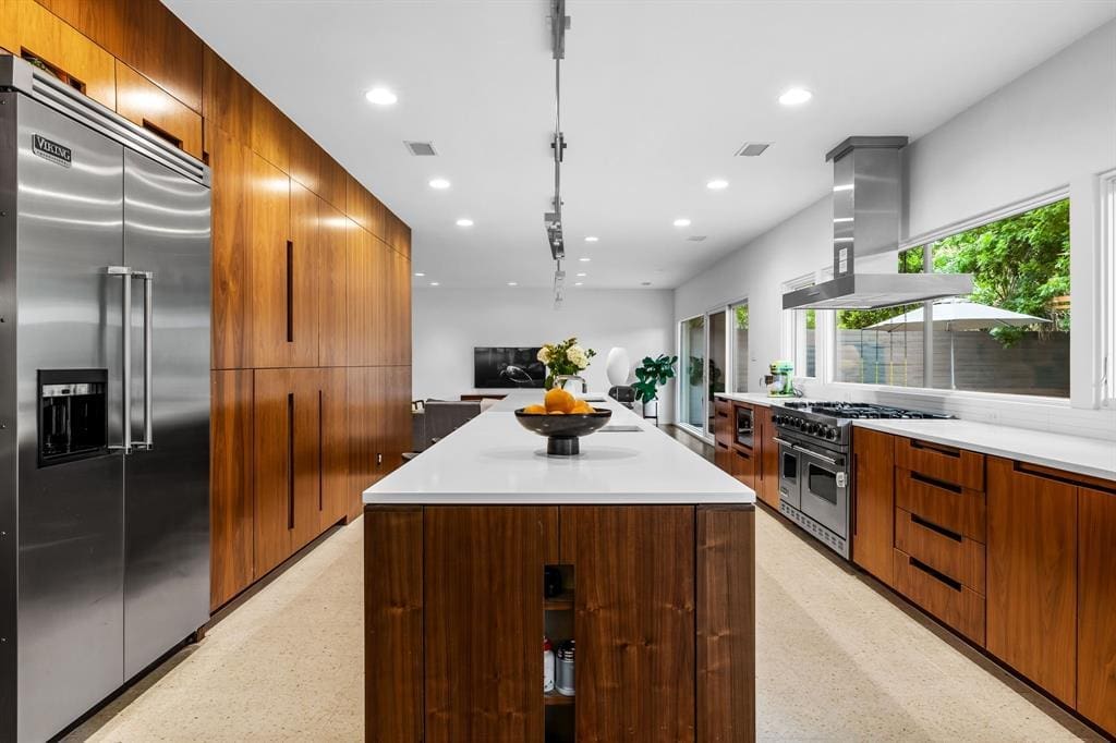 The kitchen features a six-burner range by Viking and a built-in refrigerator. 