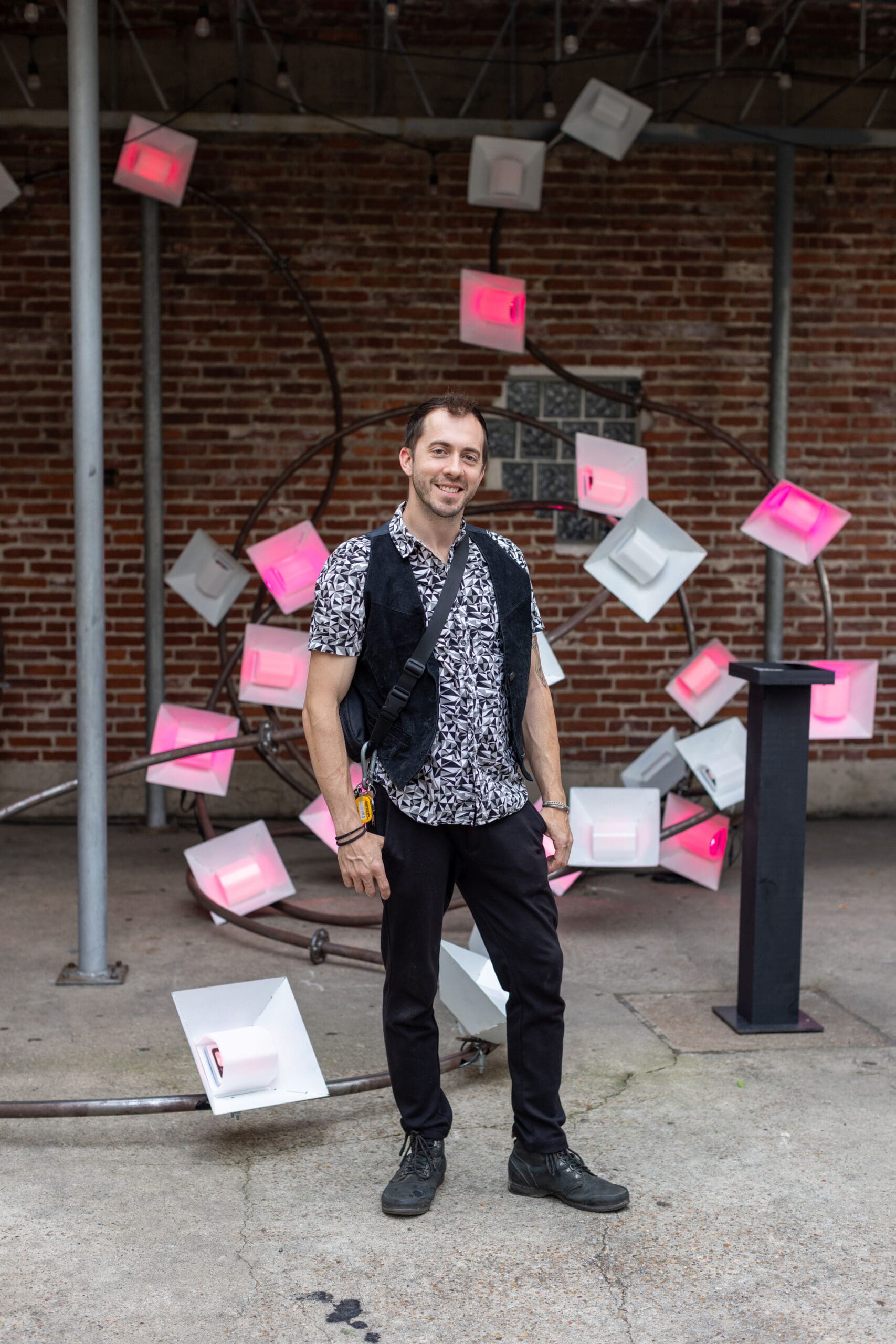 Boston Kassidy of Moon Papas Art in front of the group’s interactive sculpture at the 2024 Glasstire Party and Auction (Photo by Jenny Antill)
