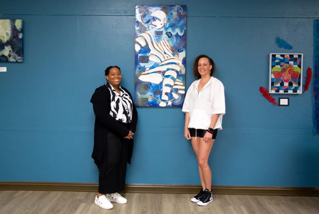 Brittany Ellis and Nicole Durham, both multimedia artists, pose with their collaborative project. (Photo by Derik J. Mercado)