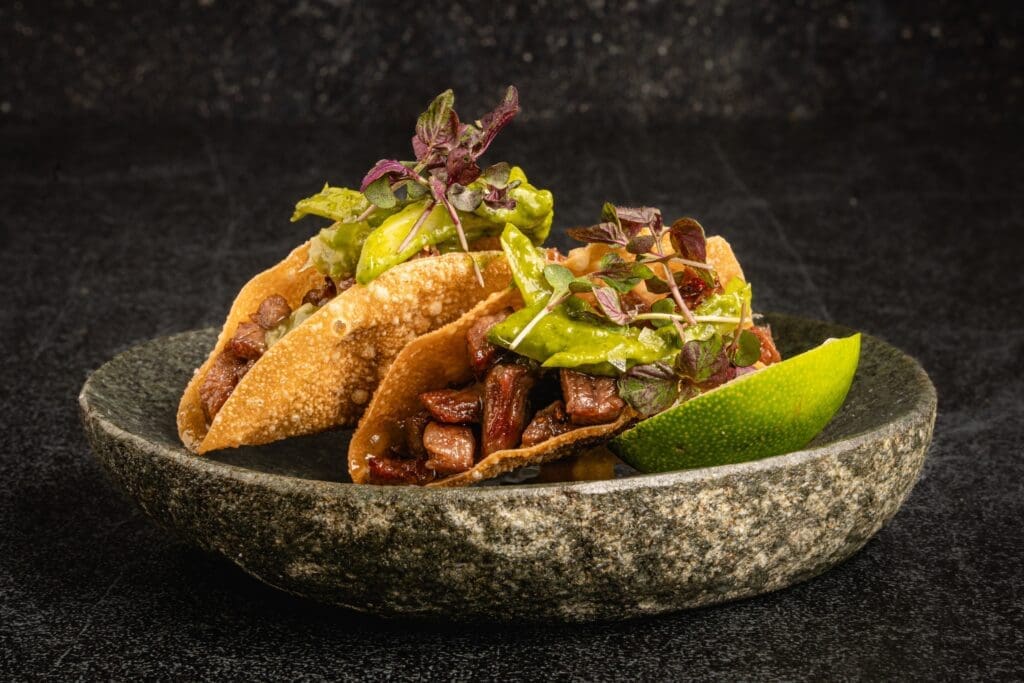 One of Toca Madera's signature apps is the crispy wonton taco (two per order, $34) cradled with A5 Wagyu, wasabi, spring onions and delicate micro shiso leaves. (Photo by Alonso Parra)