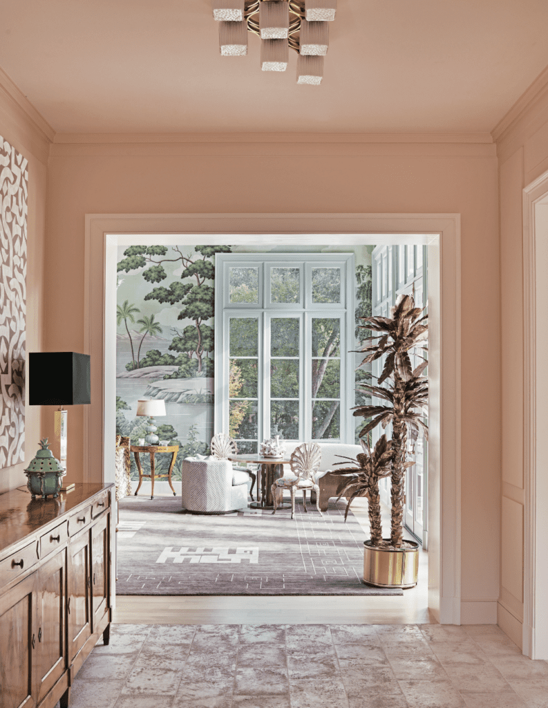 In a hallway off the entry, walls are painted Benjamin Moore Love Story pink. Ceiling fixture from John Gregory Studios. Mid- century brass palm tree from Ceylon et Cie.  (Photo by Richard Powers)