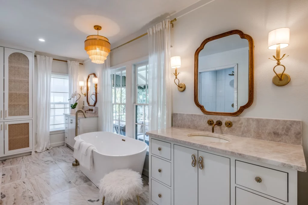 An updated primary bathroom with a standalone tub and two vanities. 