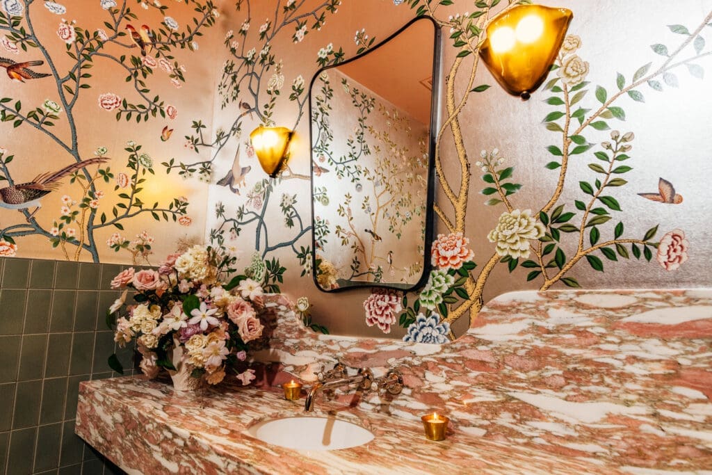 Those who make a trip to The Marigold Club's elegant marble-lined “loo” find themselves in arguably the prettiest power room in the city, appointed with handcrafted wallpaper by the famed French firm de Gournay. (Photo by Arturo Olmos)