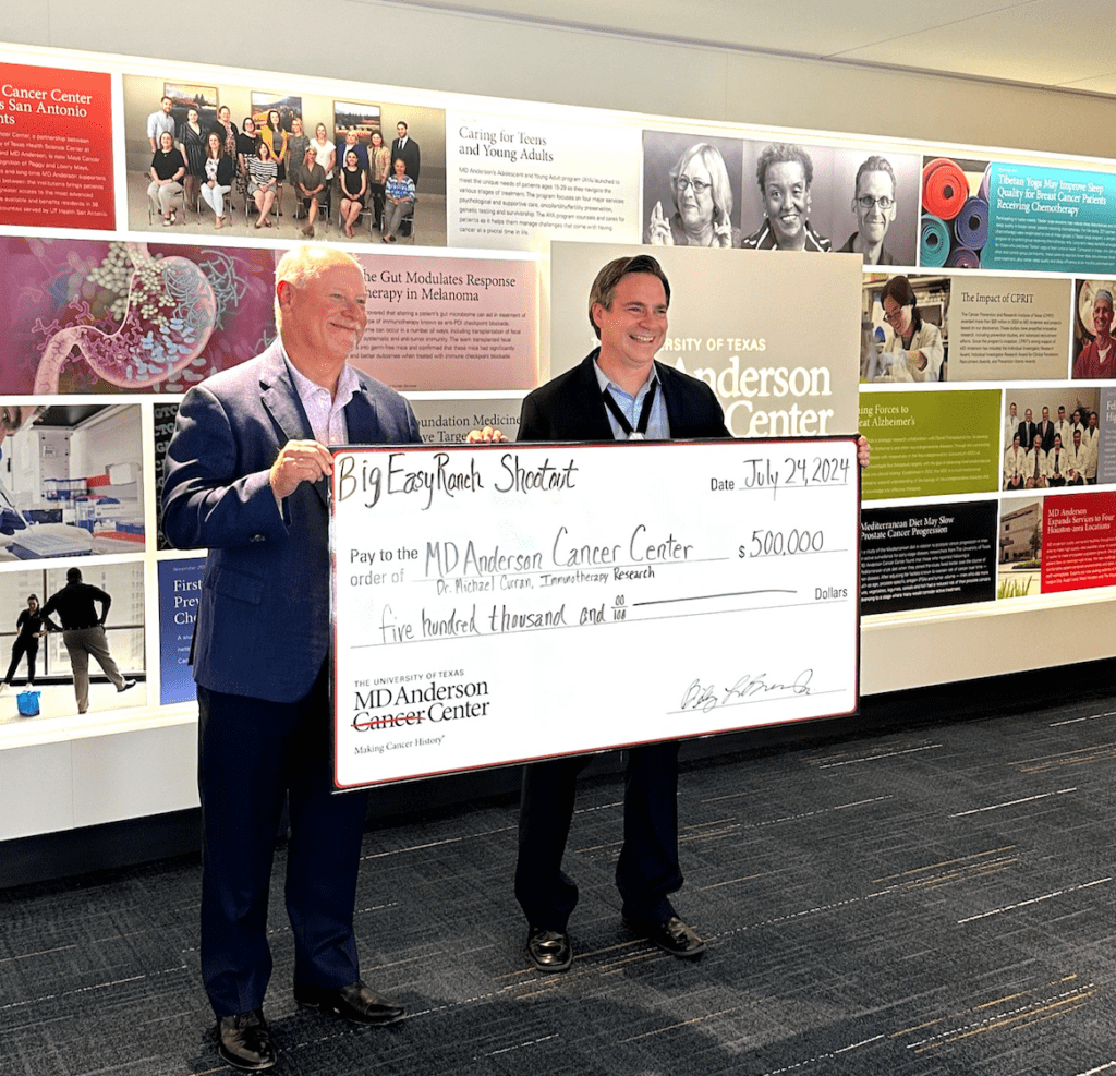 Big Easy Ranch owner Billy Brown presents the check to Dr. Michael Curran of MD Anderson's Department of Immunology. 