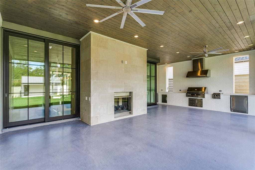 A covered back patio with gas grill.
