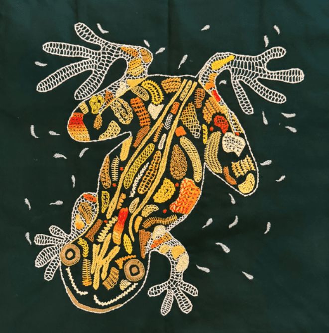 Honduran artist Rossana's embroidered design of Carter Ernst's frog drawing leaps off the fabric, as part of the “Side by Side, 20 x 20: Honduras Threads” exhibition.