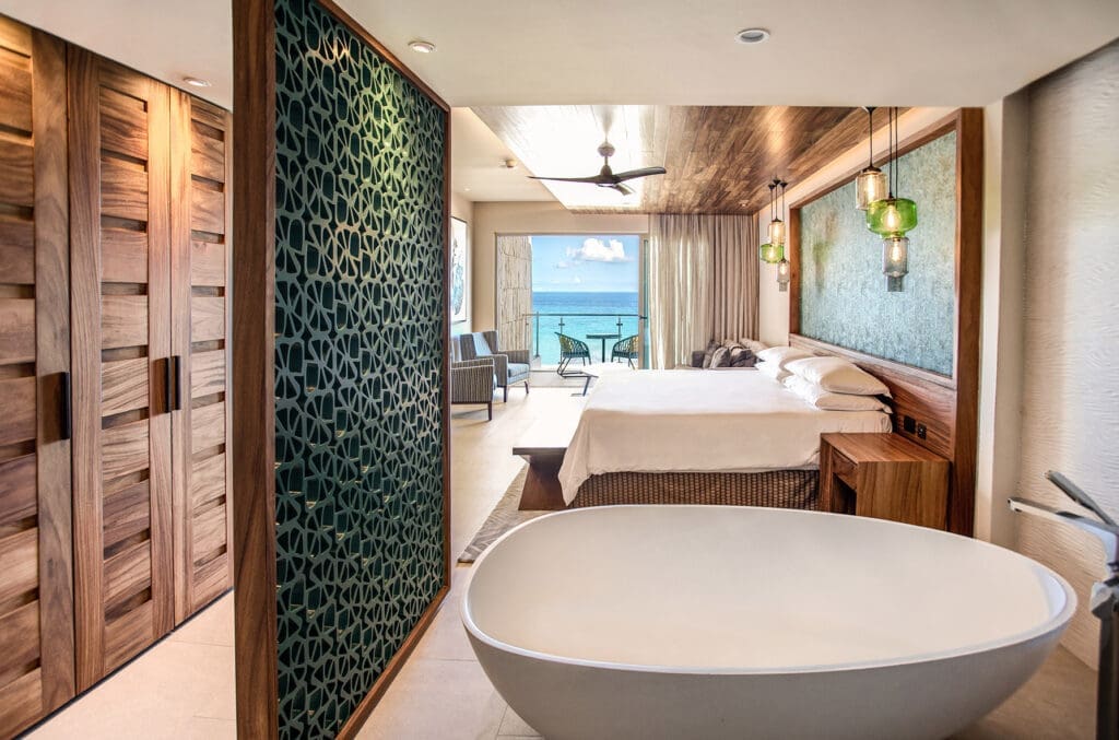 A room at Palmaïa features a spacious bathtub, sitting area, king-size bed and double sinks. Guests can step directly from the patio into the pool for a seamless indoor-outdoor experience. Room rates start at $850 for two adults. (Photo courtesy Palmaïa-The House of Aïa)