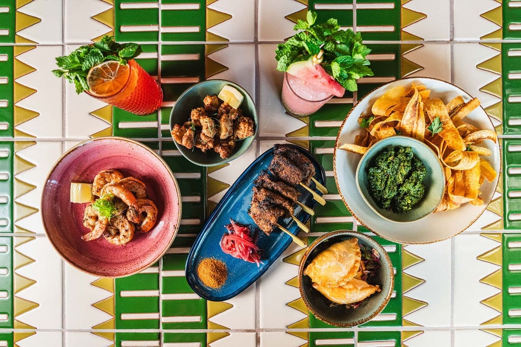 A vibrant aerial view of a beautifully arranged table spread, showcasing a delightful selection of West African dishes. Each plate invites a culinary journey through the rich flavors and traditions of Nigerian cuisine. (Photo by StuffBenEats)