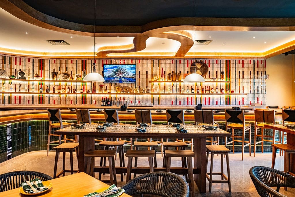 The bar and community tables pay tribute to the traditional West African woven fabric, Aso Oke, featuring a pattern designed by Nigerian American textile designer Shade Akanbi. (Photo by StuffBenEats)
