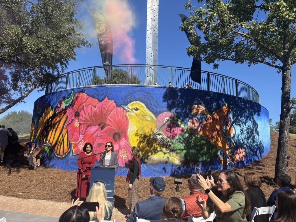 Artist Amy Malkan (l) with The Woodlands Township's Cindy Heiser (c) and artist Marlo Saucedo (r) at the unveiling of the 50th anniversary mural on The Woodlands Waterway. (Photo by Laura Landsbaum)