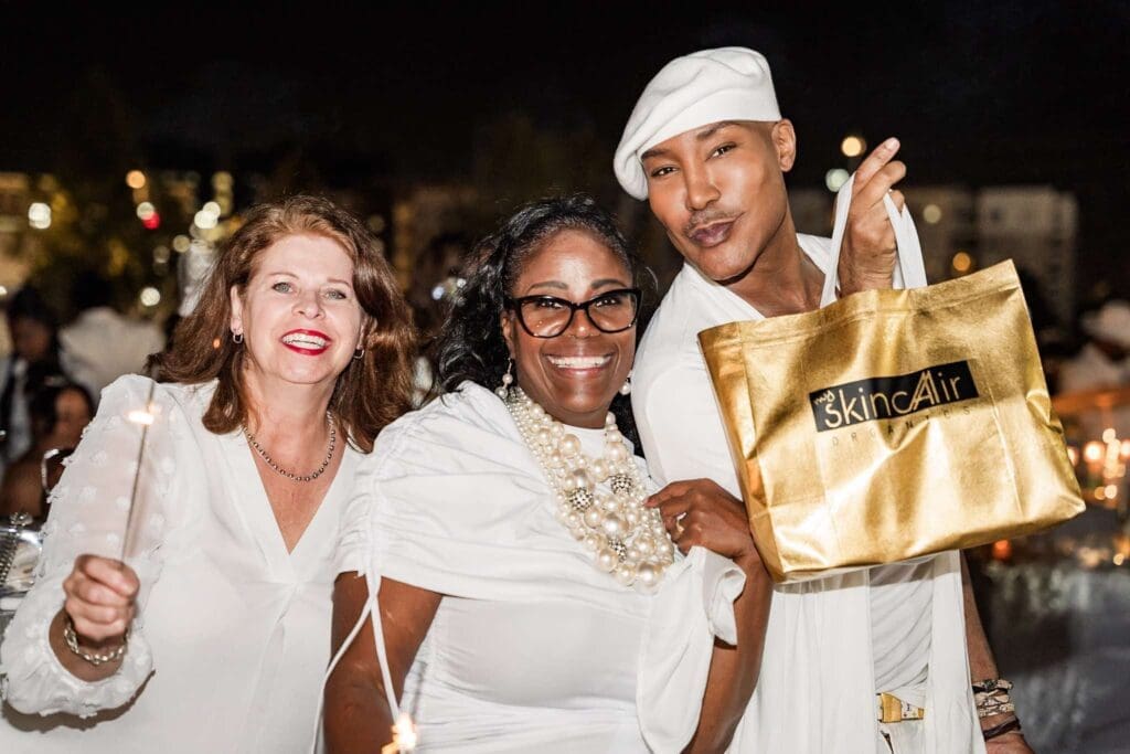 Tara Fase, Paula Nelson and Marc Harvey celebrating at Le Diner en Blanc at TMC Helix Park in the Texas Medical Center (Photo by Timeless Media DEB Houston)