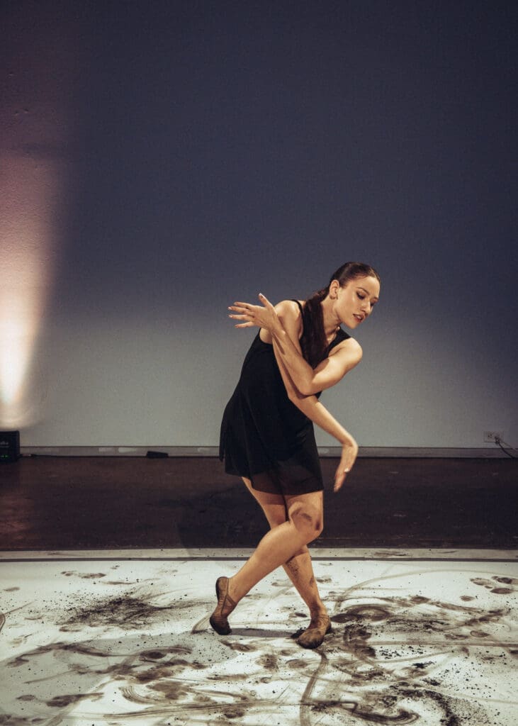 For this performance (which took place on three different pieces of paper in the large gallery), the group decided to create art on paper by putting charcoal on the dancers' feet. (Photo by Ethan Rios)