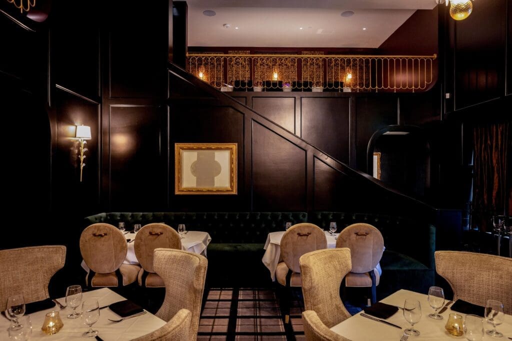 The dining room of the new Leo's is cloaked in ebony-colored wood paneling, floor to ceiling, and guests are cosseted in the coziest of dining chairs; come the dinner hour, a pianist plays the baby grand tucked in a corner. (Photo by Andrew Hemingway)