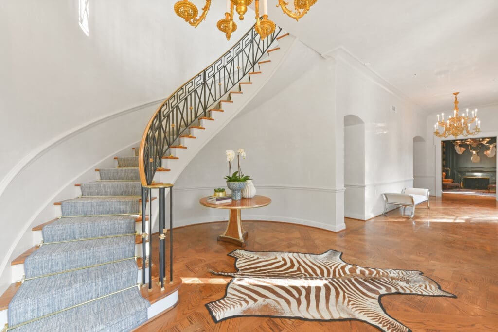 The sweeping staircase that welcomes guests to the foyer of the River Oaks home.