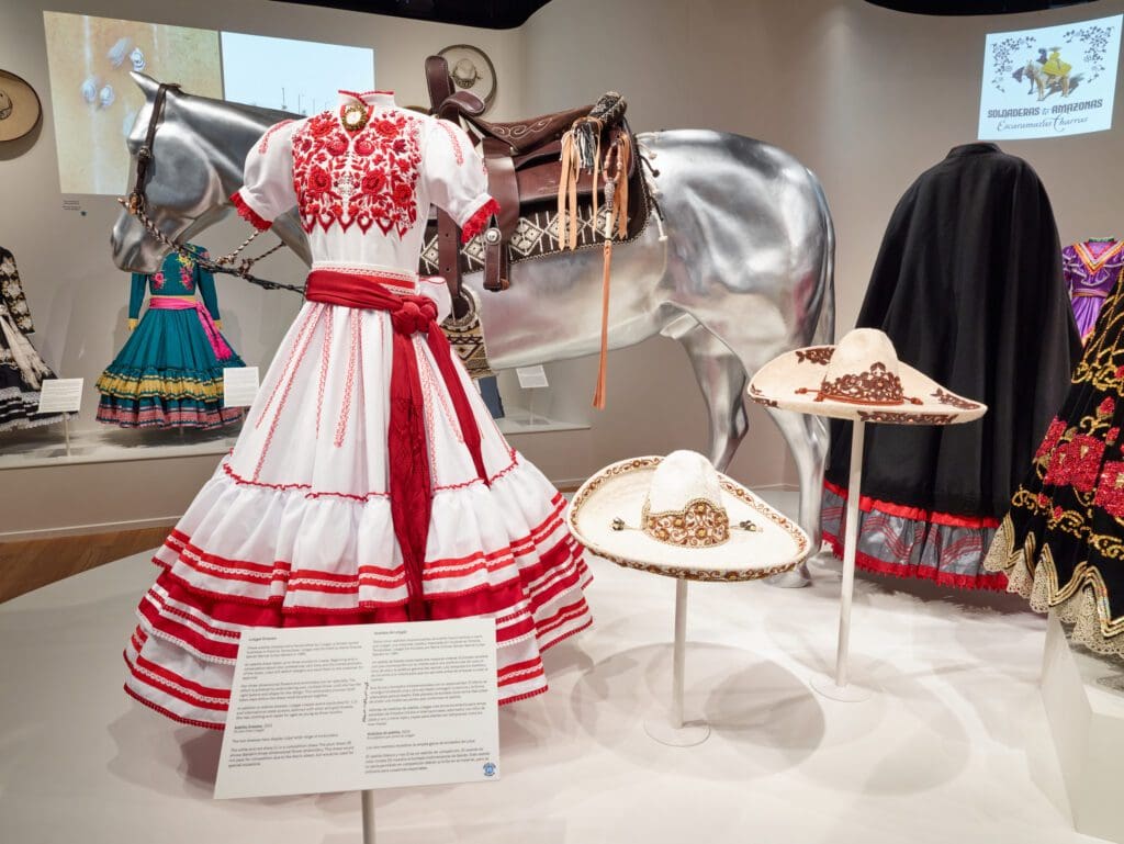 One striking white and red escaramuza charra dress, adorned with intricate floral embroidery, showcases the meticulous craftsmanship and vibrant traditions of the sport. (Courtesy Chad Redmon)
