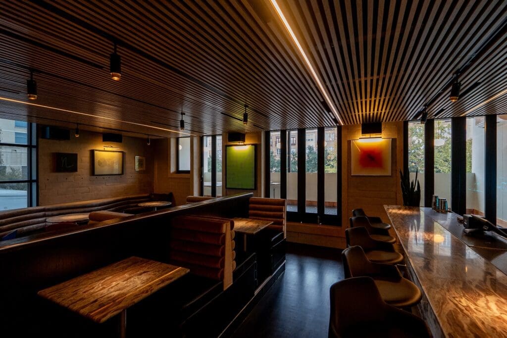 Brittany Vaughan of Garnish Design reimagined Lee's with chrome-accented ebony-colored wainscotting, soft black leather accents, gray velvet and directional lighting. (Photo by Carla Gomez)