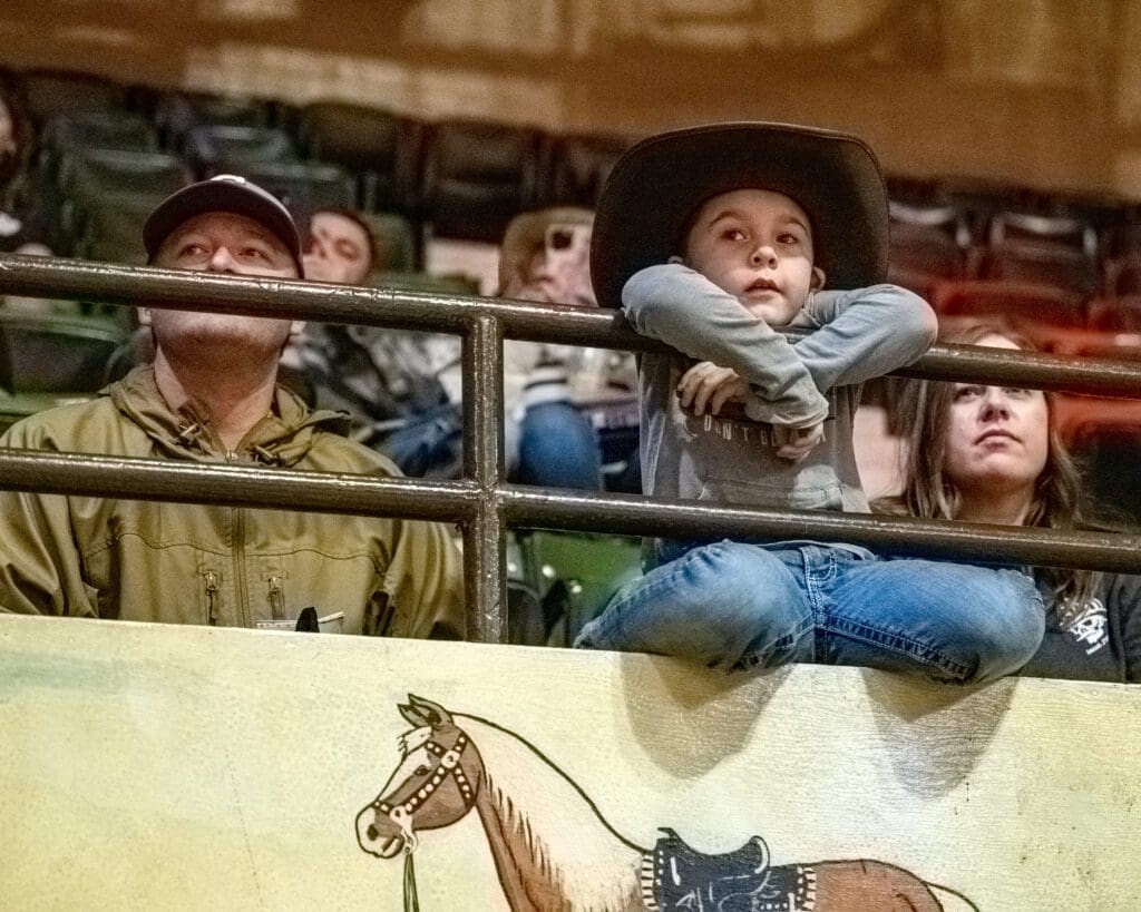 A young cowboy looks on at the Will Rogers Coliseum as contestants competed blow.  (Photo by Walt Burns)