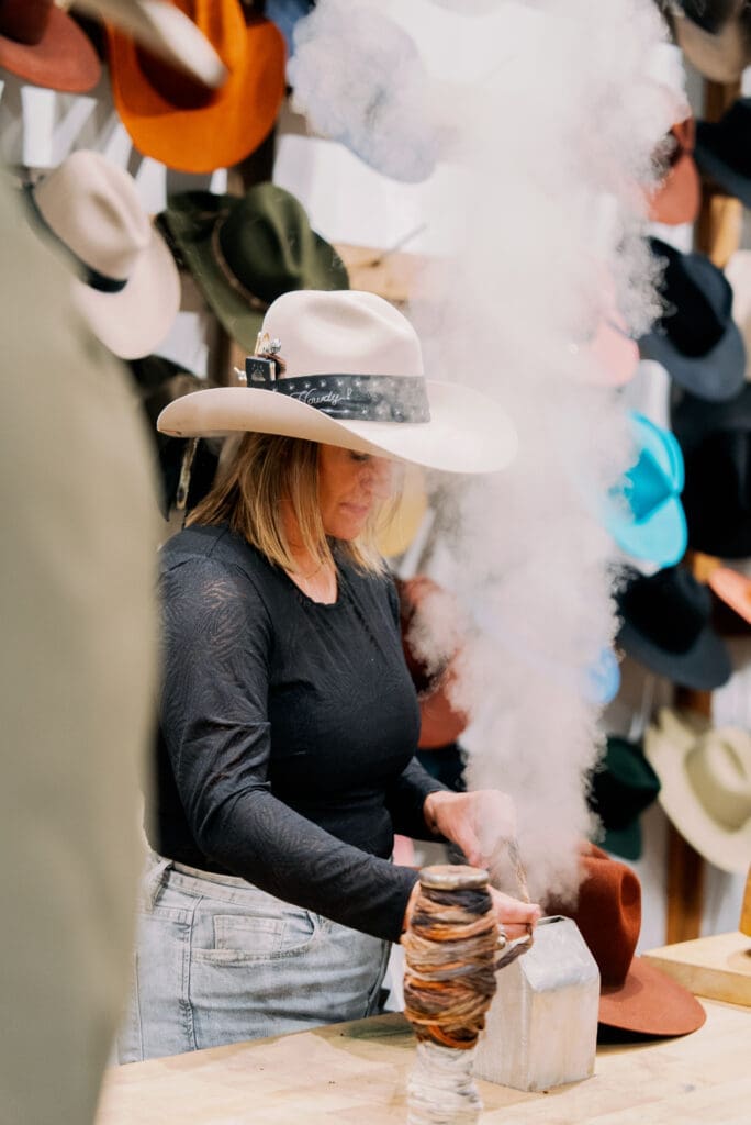 Chelsey Lowe spent the night customizing cowboy hats with Kemo Sabe’s personal touches. (Photo by Nan Studios)