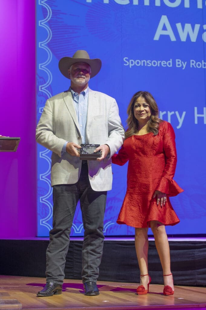 Preston Hagman accepting Memorial Hero Award for father Larry Hagman with emcee Clarice Tinsley (Photo by Tamytha Cameron)