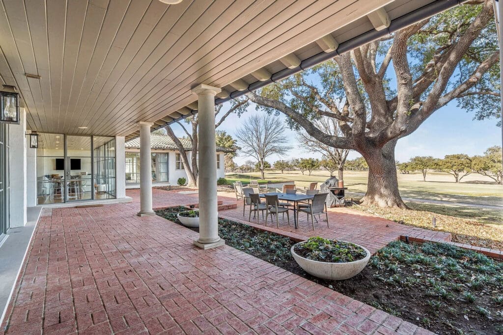 A spacious covered patio, complete with an outdoor dining area and lush landscaping, is ideal for entertaining. (Courtesy)
