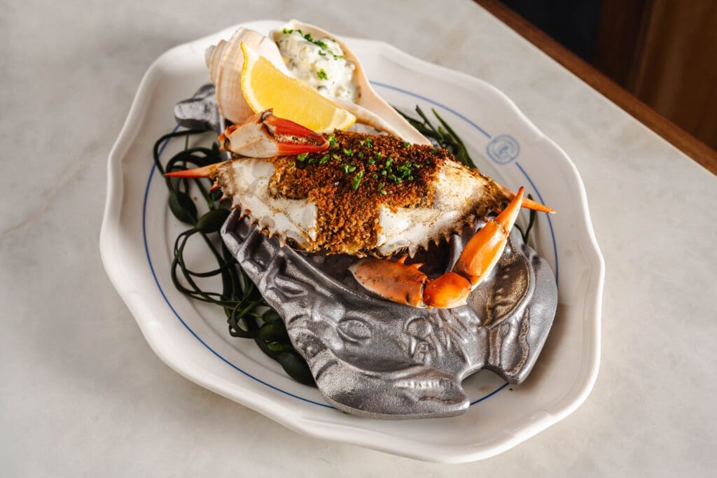Stuffed deviled blue crab with sauce ravigote and grilled lemon. Photo by Michael Anthony.