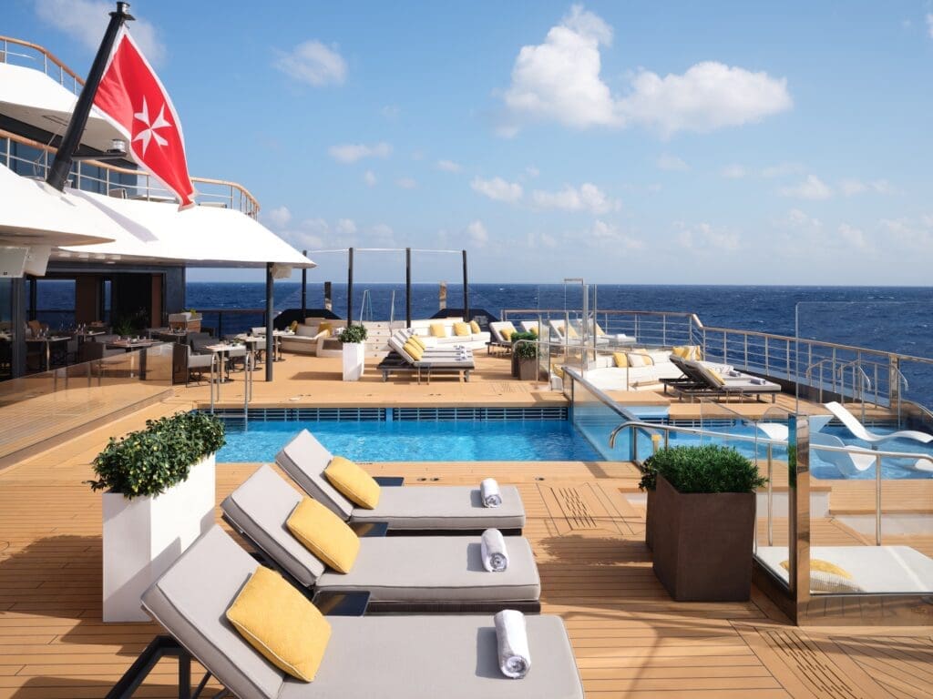The main pool with dining at The Pool House aboard the Ritz-Carlton yacht Evrima.