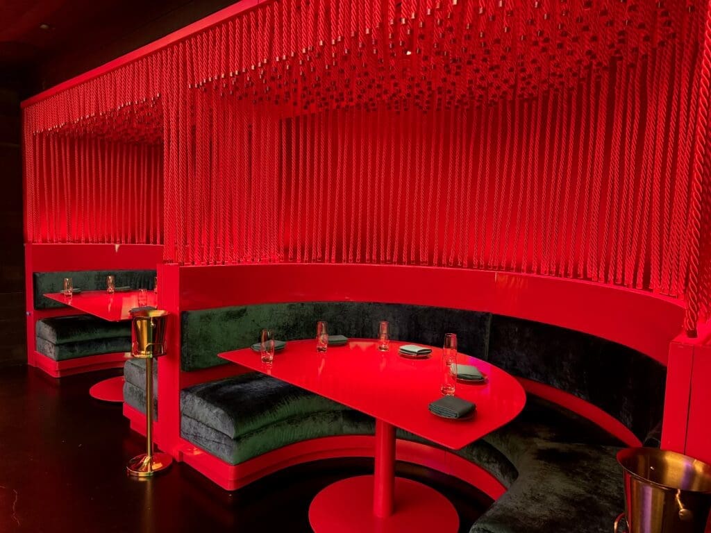 Gin Design Group has created cozy two-person alcoves with red lacquered tabletops framed with rows of hanging silken crimson cords at Haii Keii.  (Photo by Karter Kendrick)