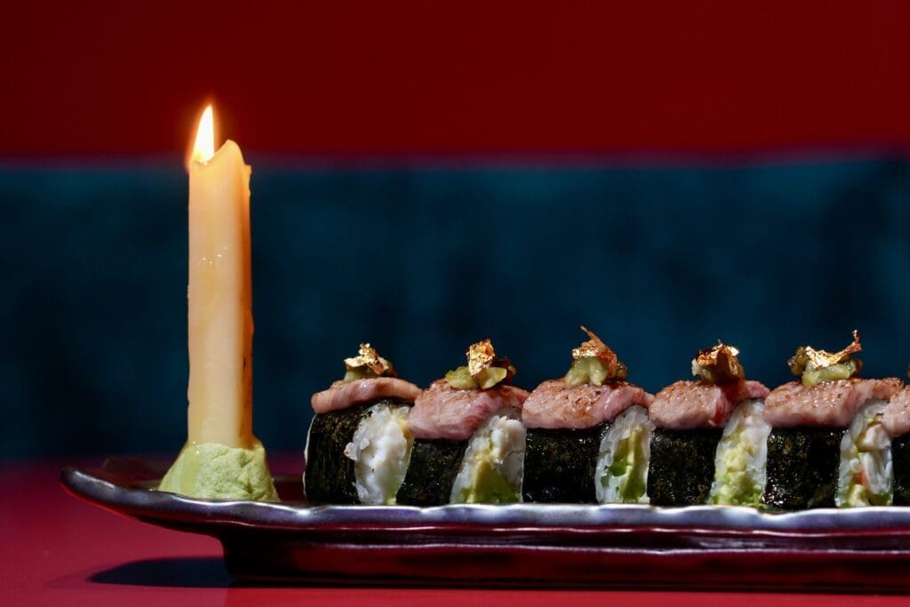 The Murakami roll, a luxe creation featuring king crab, Japanese A5 Wagyu, Kaluga caviar and a sparkle of edible gold leaf brought to the table with a lit candle beside it made with the delicious fat of the king crab ($50). (Photo by Photos by Karter Kendrick)