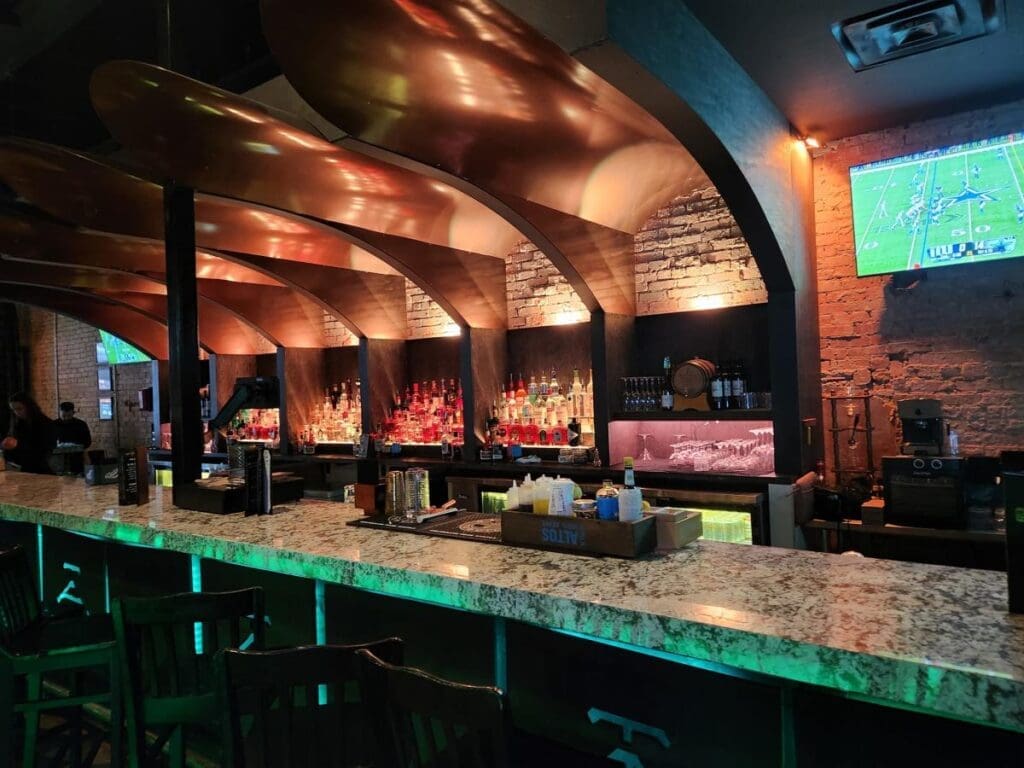 Sip craft cocktails and grab a slice from Son of a Baker while catching the game on the rooftop projector wall. (Courtesy)