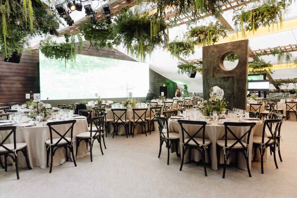 Outside and across the garden, a tent erected for the dignified occasion awaited. Extravagantly decorated with lush and verdant greenery from Bows + Arrows, the tent transported guests. (Photo by Vanessa Chavez)