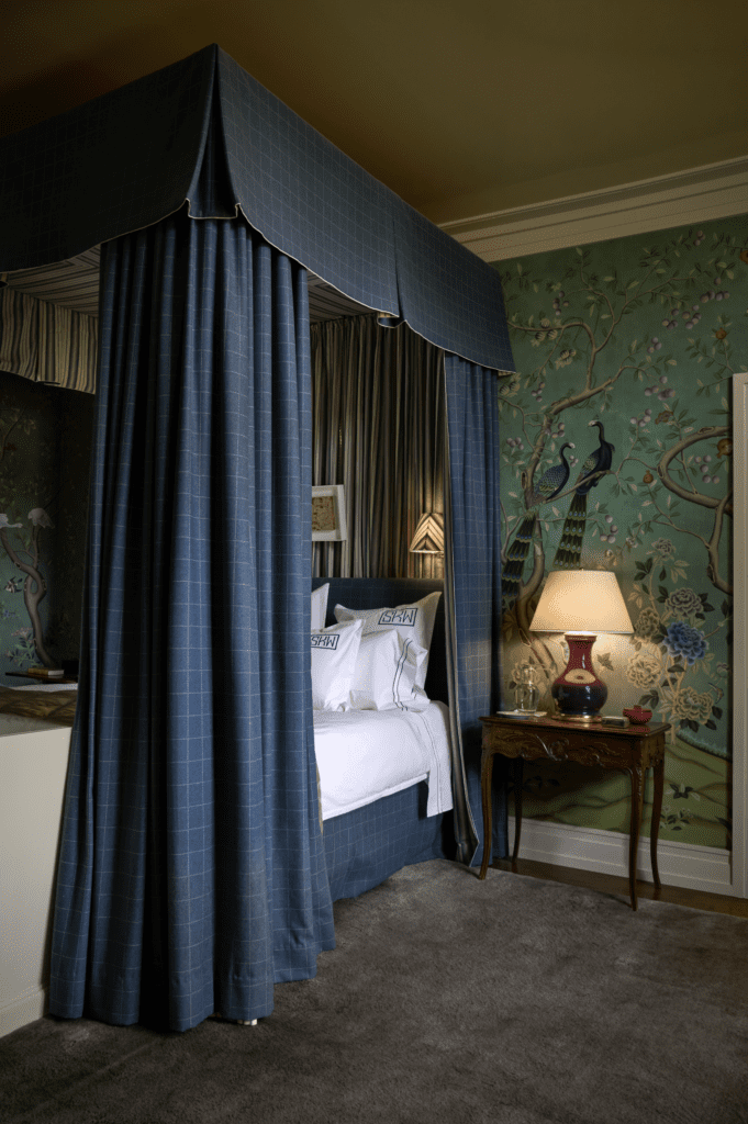 The primary bedroom wallpaper is de Gournay. Canopy in Lee Jofa windowpane pattern fabric and 
Rose Tarlow stripe fabric. 
Christopher Spitzmiller lamp.  (Photo by Pär Bengtsson)
