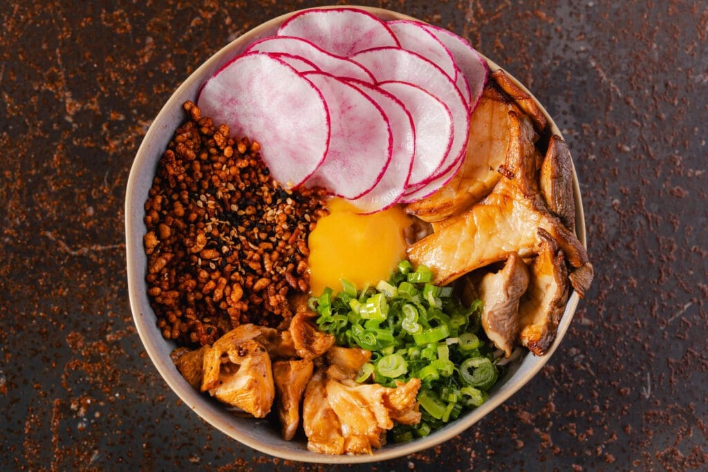 The popular Japanese dish, donburi ($20), is a warm, comforting vegetarian bowl filled with sauteed King trumpet and hedgehog mushrooms, radish, caramelized onions, and an egg over Koshihikari rice, seasoned with a puffed rice furikake. Photo by Michael Anthony.