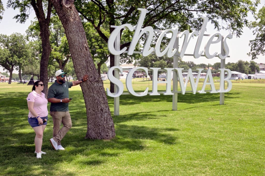 The oversized Charles Schwab sign on Colonial’s lush lawn proved a popular photo stop for fans throughout the weekend. (Photo by Walt Burns)