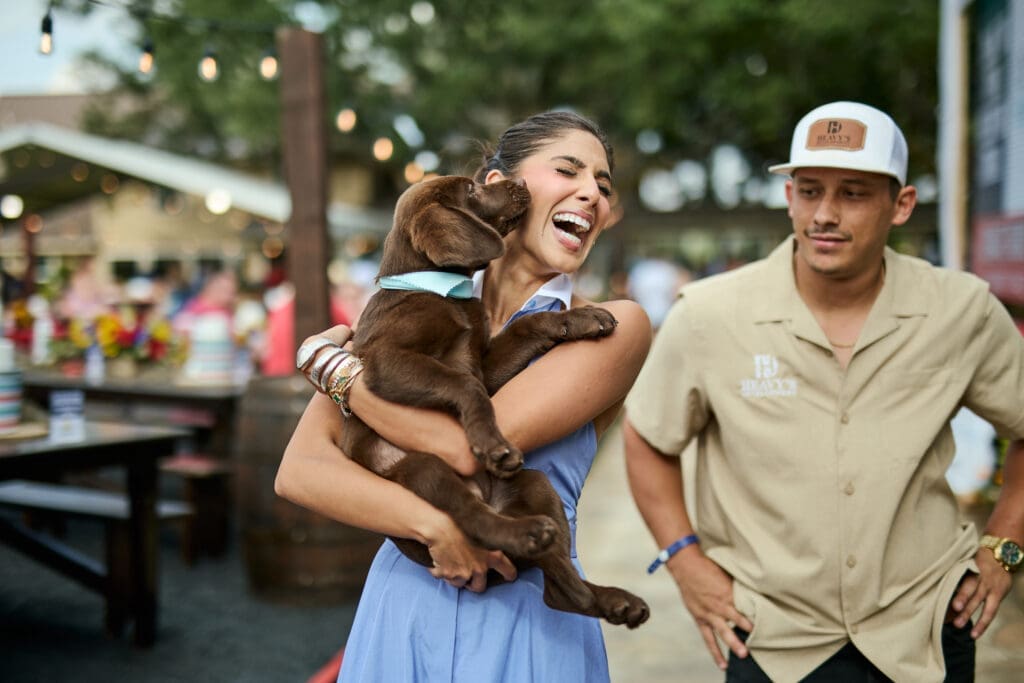 Zinat Ahmed snuggles with the chocolate lab at the 13th annual CrawFest  (Photo by courtesy of Cotton Holdings)