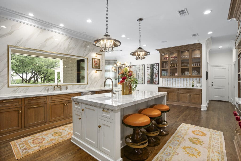 A chef-worthy kitchen balances warmth and precision with Neolith countertops, WaterStreet Brass hardware, and a custom onyx table framed by mid-century inspired pendants. (Freeze Media)
