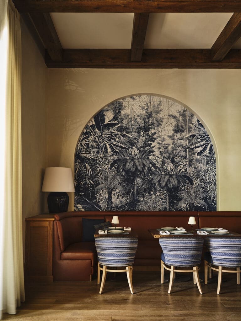 The ivory hand-troweled plaster walls are adorned on one side with several graceful arches inset with an azure-hued tropical wallcovering. Photo by Frank Frances.