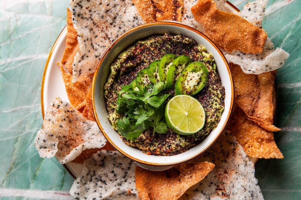 sesame guac made with a splash of soy sauce and sesame oil before it’s topped with a crunchy combo of fried shiso crunch served with fried wonton and rice chips ($11) (Photo by Photos by Becca Wright)