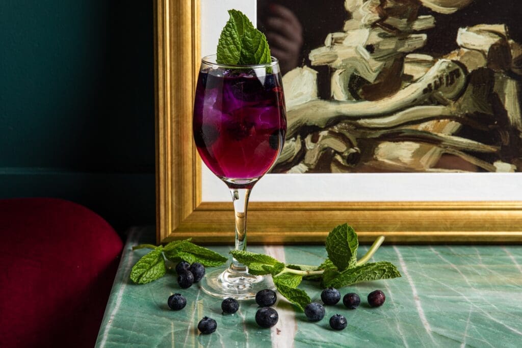 Guests can sip on refreshing coastal-inspired cocktails like The Houstonian, made with Butterfly Pea Gin, Fever Tree Tonic, a splash of Creme de Violette, and spices and herbs like cinnamon, star anise, juniper, and thyme. (Photo by Photos by Becca Wright)
