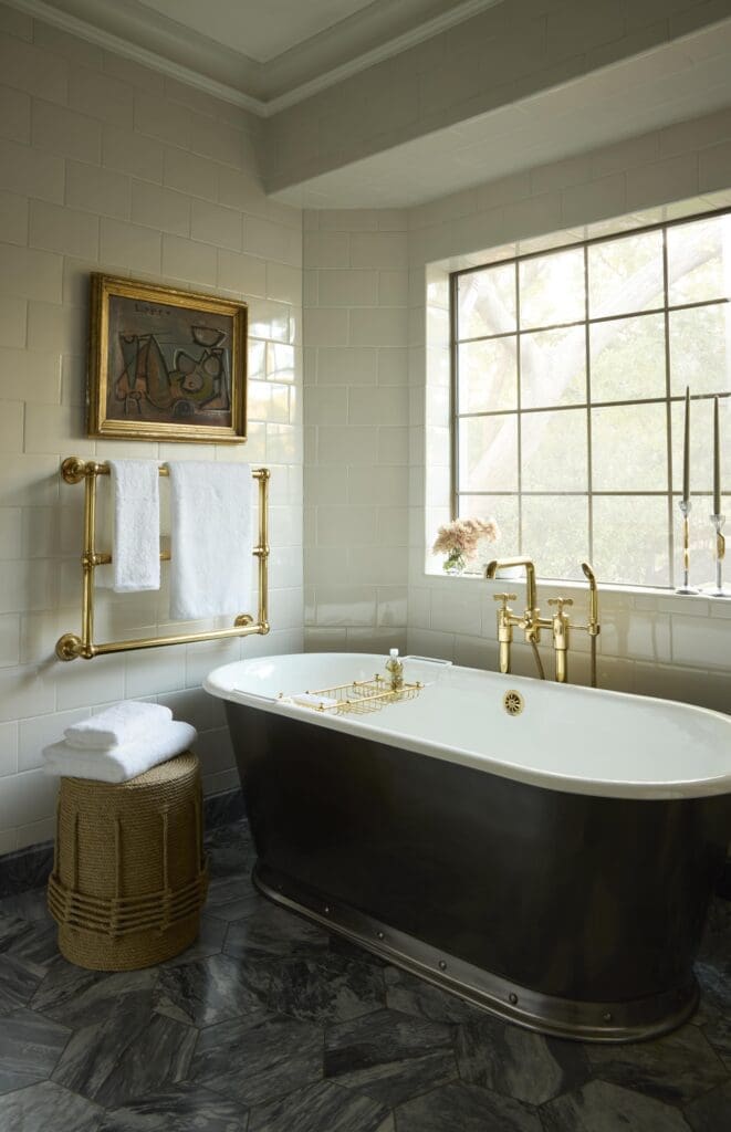 Voltaire iron bathtub with burnished nickel exterior. Waterworks plumbing fixtures and tile. Bardiglio marble floor. Artwork by Lucia Lopez. Christian Astuguevieille stool.  (Photo by Kristopher Ellis)