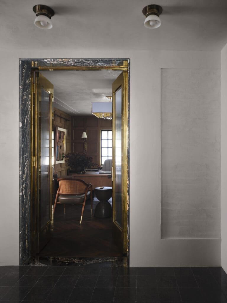  Looking into Moore’s office at his studio, the custom polished-brass doors are by La Fragua Metal Works. Marble door frame. Rocky Mountain Hardware. Piedmont stone floors. Plaster-finish walls by Chateau Domingue. Flush mount fixtures by The Urban Electric Co. (Photo by Douglas Friedman)