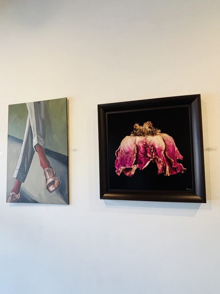 An installation view of Archway Gallery's 17th Annual Juried Exhibition. Pictured Left to Right: Grant Pilon's painting "Conspicuous Socks" and Patti Gary's "Rose Couture." (Photo by Ericka Schiche)