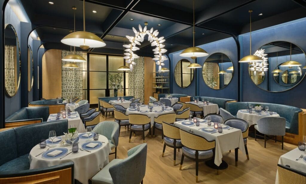 Bathed in deep navy and framed by velvet drapes, The Blue Room at The Crescent Hotel offers an intimate, modern setting with sculptural lighting and contemporary art. (Photo by Jason Dewey and The Crescent Hotel Fort Worth)
