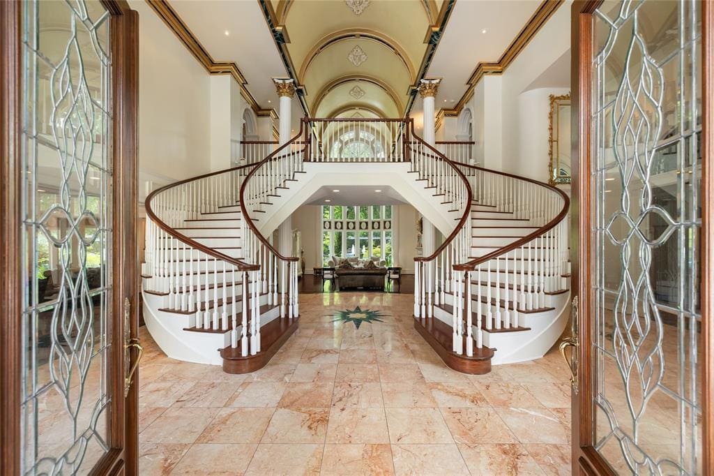 Dual staircases give an elegant welcome as you step inside. 