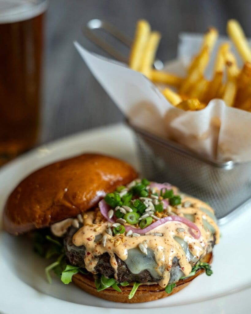 The Kitchen’s buffalo burger brings heat with harissa aioli, Swiss cheese and a punch of crunch. (Photo courtesy of The Kitchen)